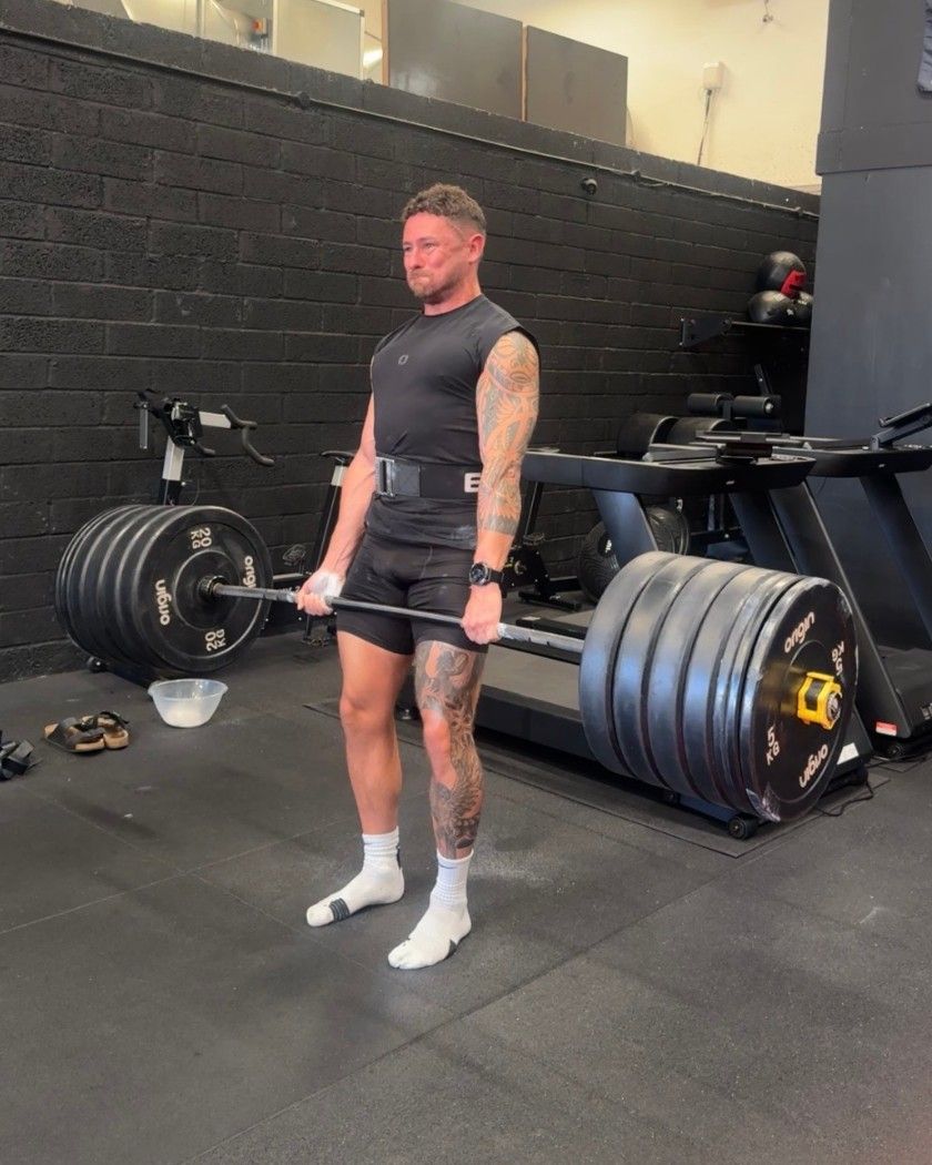 Mikey locking out a heavy deadlift in the gym