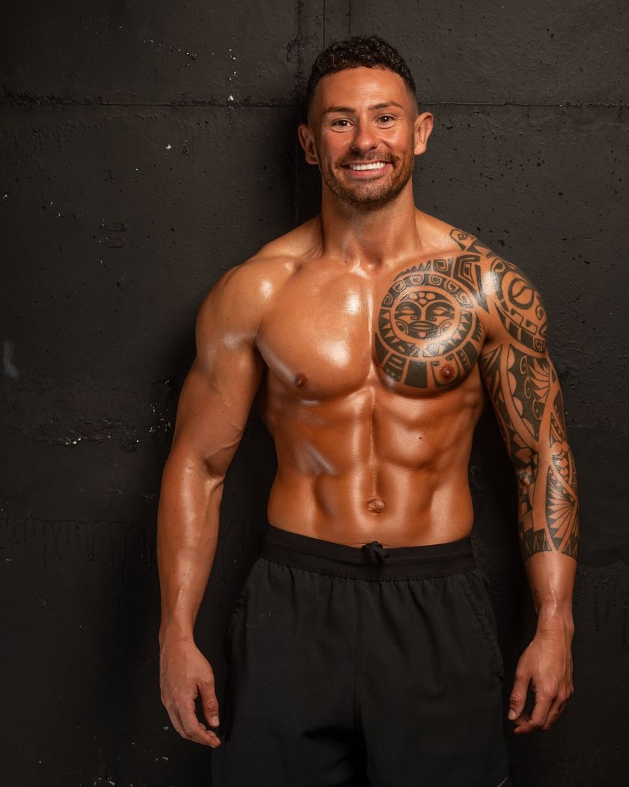 Mikey physique photo against a dark wall